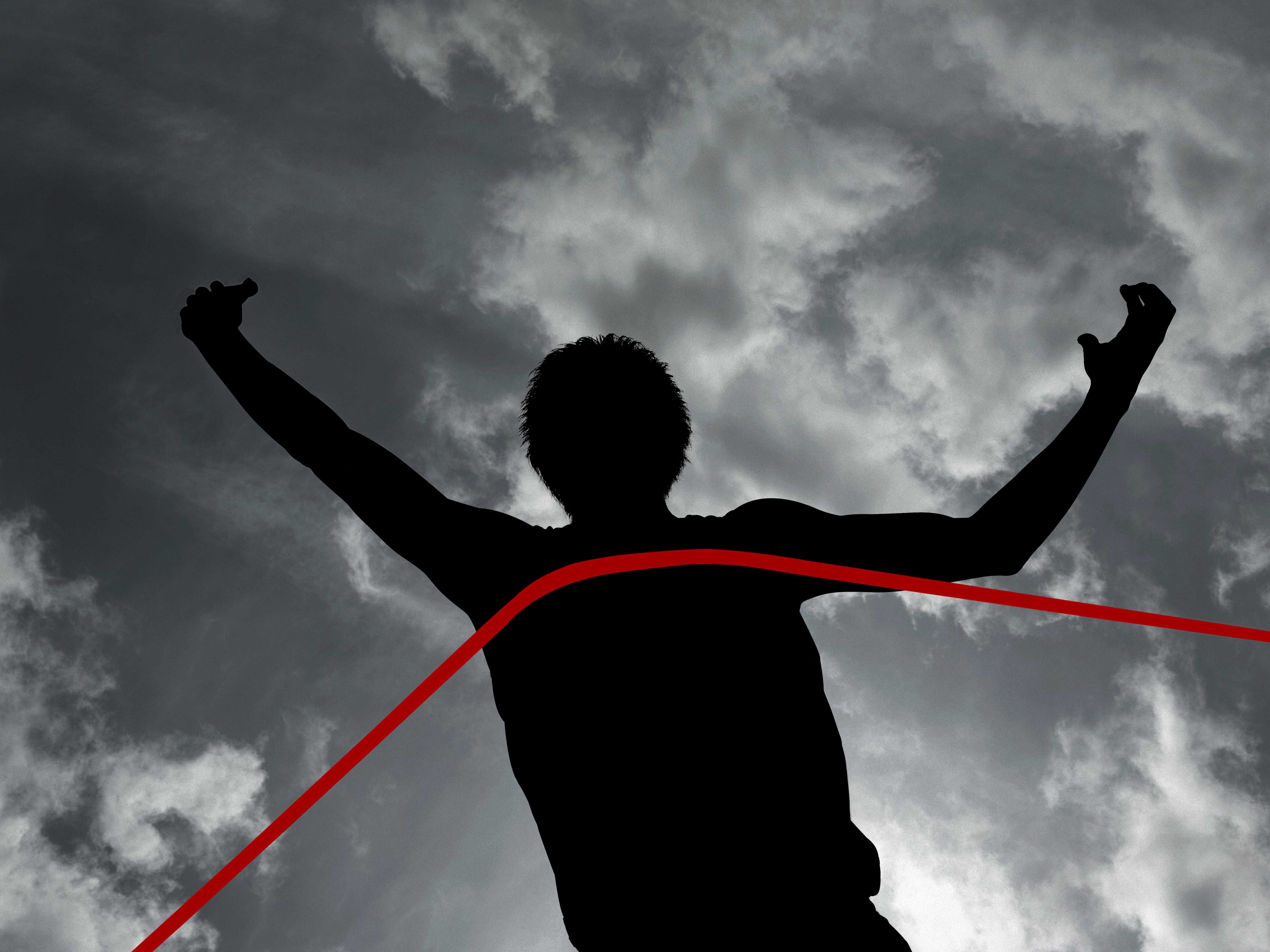 Black man frolicking Silhouette of athlete at finish line