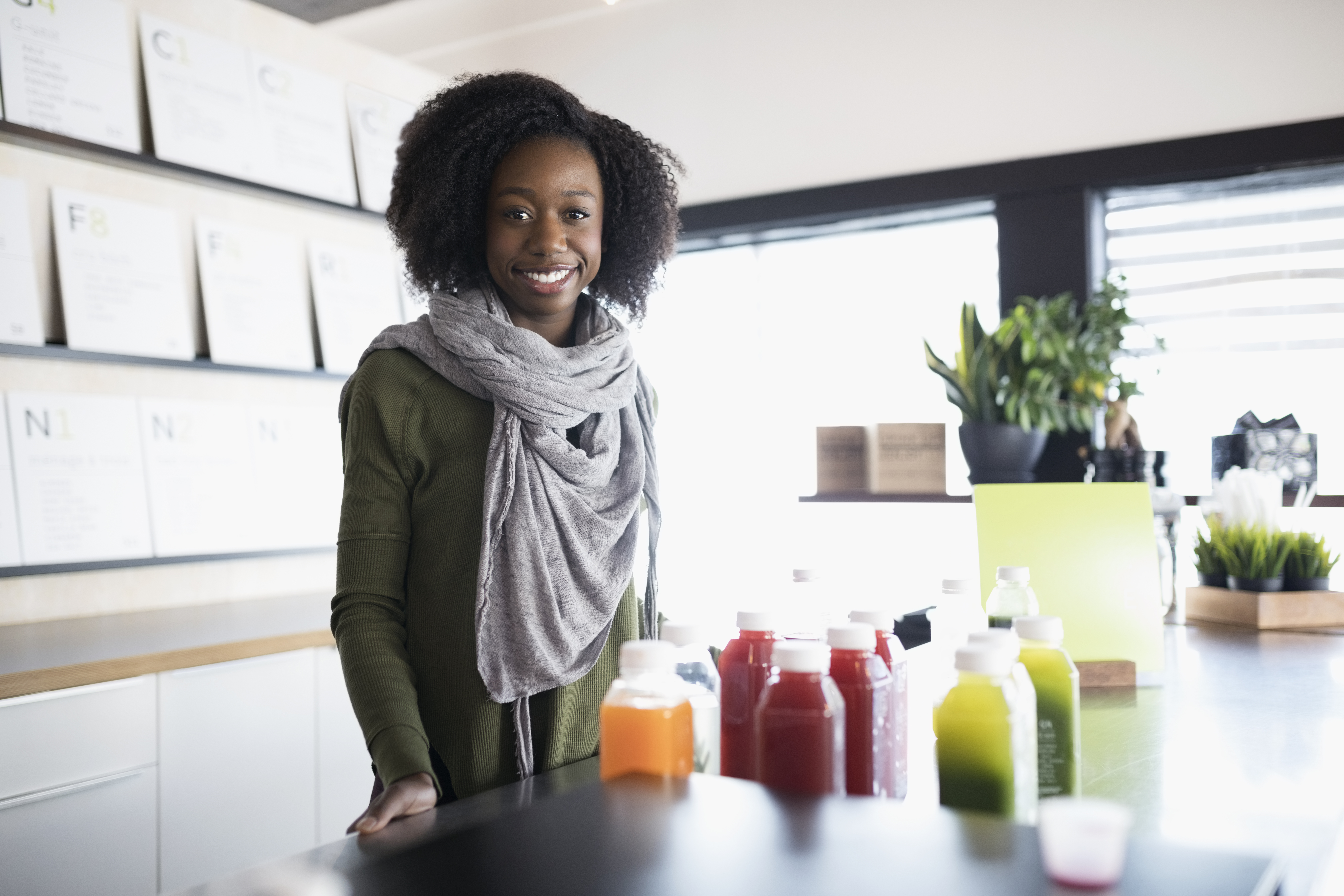 Portrait smiling young woman working at juice bar