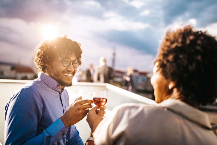Happy black businessman toasting with his colleague on a rooftop party.