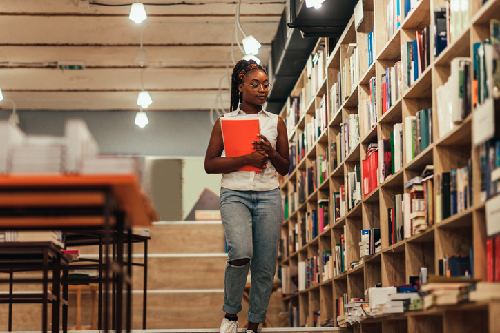 Female student searching for books in the campus library